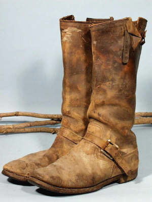 Black boots that have turned brown with age.